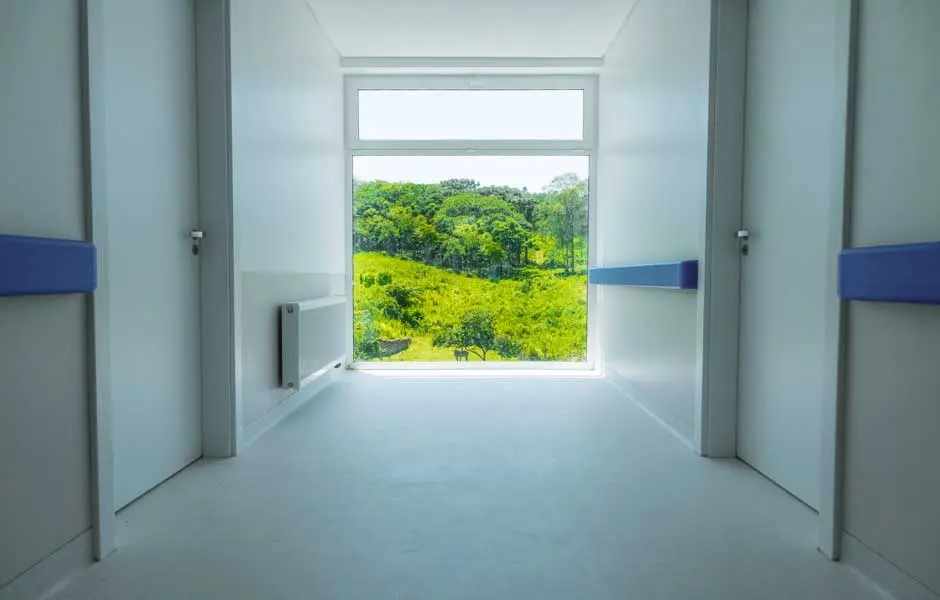 Corredor interno do Serraville com janela ampla voltada para a área verde
