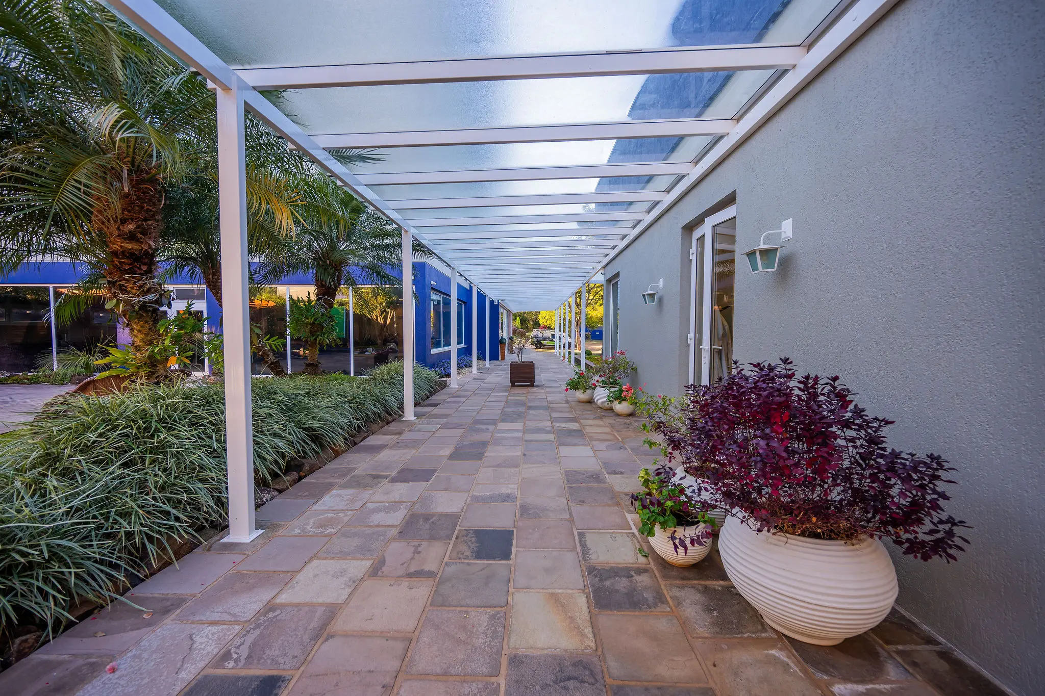Corredor externo coberto com jardins laterais